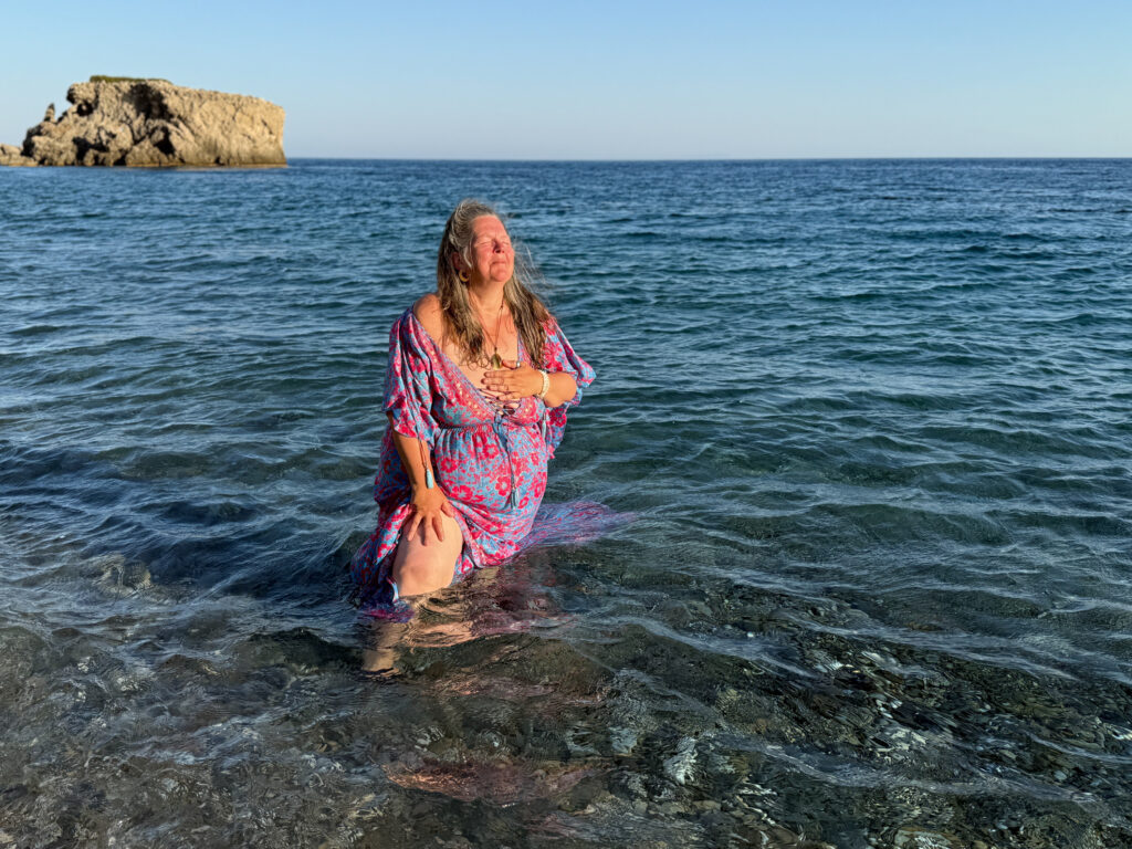Claudia Korsten-Ring steht im Meer, richtet den Oberkörper auf und blickt nach oben.