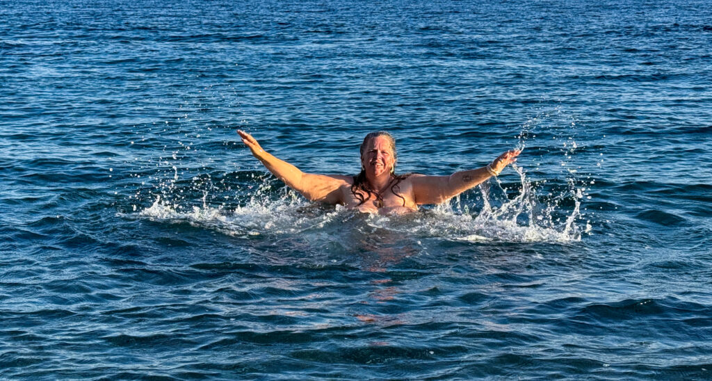 Claudia Korsten-Ring schwimmt mit ausgebreiteten Armen im Meer.